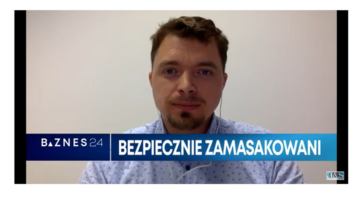 Mężczyzna w jasnej koszuli, z krótkimi włosami i zarostem. Na dole pasek z napisem: Biznes24, Bezpiecznie zamaskowani. W prawym dolnym rogu logo a&s.